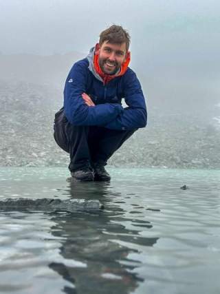 Mann in der Hocke auf flachem Wasser