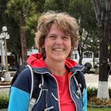 Portrait von Sabine Sorg mit Outdoorkleidung in einem Park mit Palmen