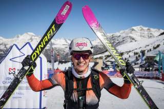Skimo Athlet hält jubelnd Ski über den Kopf