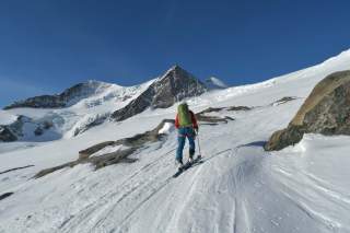 Mensch geht Skitour durch verschneite Berglandschaft