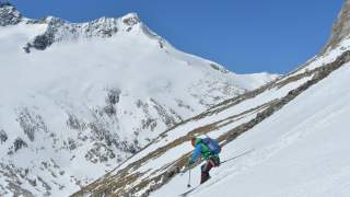 Mensch fährt mit Ski von Berg ab