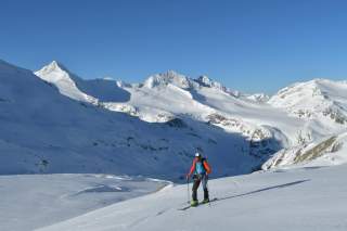 Mann auf Skitour in einsamer alpiner Berglandschaft
