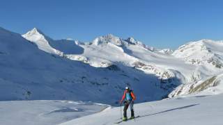 Mann auf Skitour in einsamer alpiner Berglandschaft
