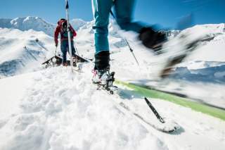 Zwei Menschen auf Skitour Richtung Hütte