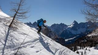Mann mit Skihelm bei Skiabfahrt im freien Gelände