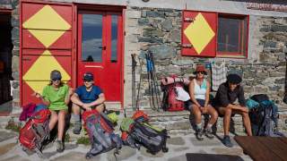 Wandergruppe sitzt vor einer Schutzhütte
