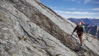Mann und Frau mit Kletterausrüstung am Berg