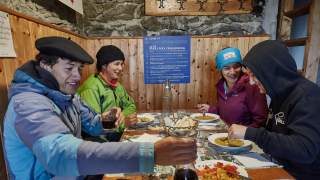 Wandergruppe beim Abendessen auf der Hütte