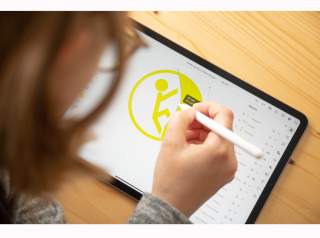Frau designt Kletter-Symbol auf Tablet Frau designt Kletter-Symbol auf Tablet