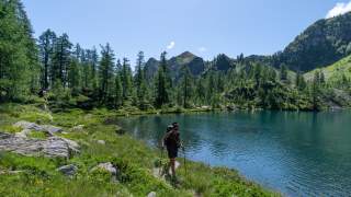 Wanderer wandert an einem See entlang.
