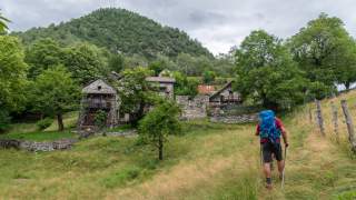 Wanderer wandert zu einem kleinen Steindorf