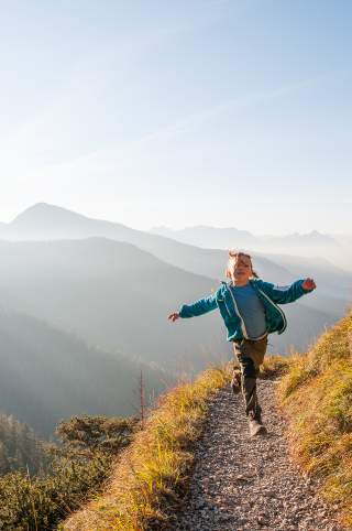 Kind läuft auf Bergweg