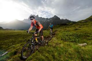 Zwei Menschen mountainbiken in den Bergen