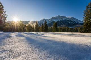 Winterlandschaft mit Sonne und Bergen