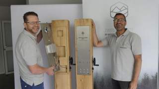 Zwei Handwerker vor zwei Holzsäulen, die als sogenannte Zwitscherkiste fungieren werden.